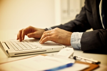 Businessman sitting in office, working with laptop computer