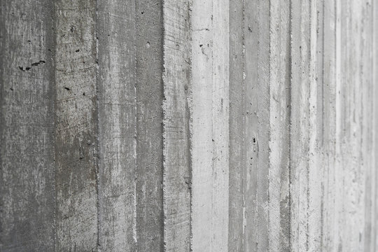 texture of wooden formwork stamped on a raw concrete wall as bac