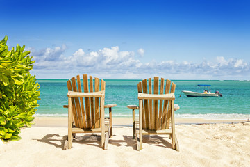 Two beach chairs on tropical shore, horisontal composition