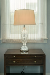 white lamp on bedside wooden table in luxury bedroom