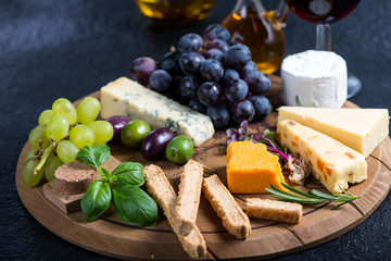 Cheese board with fresh grapes,herbs and olives