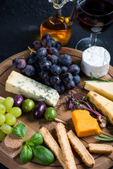 Cheese board with fresh grapes,herbs and olives