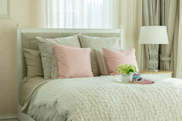 Fototapeta na wymiar luxury bedroom interior with pink pillows and white tray of flow