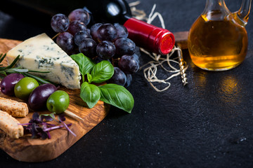 Food background,rustic board with cheese herbs and wine