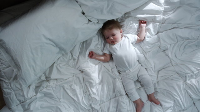 baby asleep on a big bed