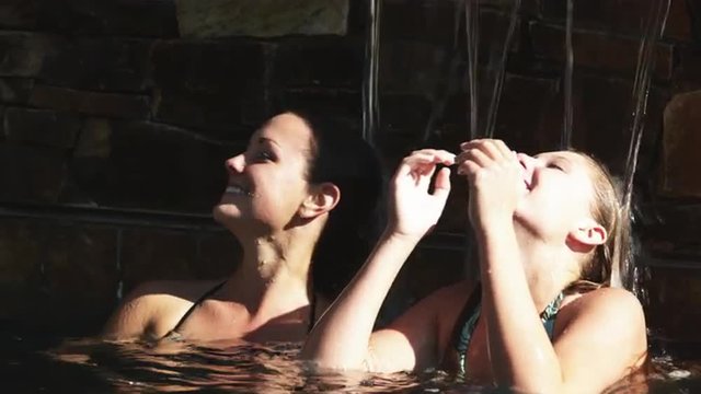 SLO MO MS Two teenage (16-17) girls relaxing in swimming pool, American Fork, Utah, USA