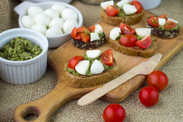 Bruschetta with fresh tomatoes, mozzarella and  herb pesto