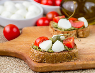 Bruschetta with fresh tomatoes, mozzarella and  herb pesto