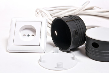 Electric sockets and power cable on white surface