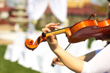 Girl playing on the violin outdoors. Musician for the wedding