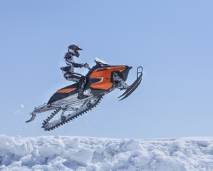 Snowmobiles in flight against the blue sky