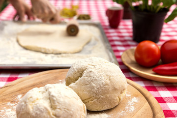 Frau rollt Teig auf Backblech aus
