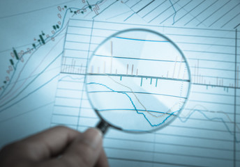 Magnifying glass with financial graph