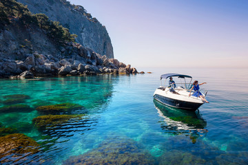 Woman relaxing on boat in sea near rocky shore. Traveling island