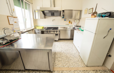 kitchen stainless steel with large gas stove and a meat slicer