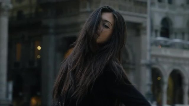 Slow motion/pan up of woman posing and lifting arms / Milan, Italy