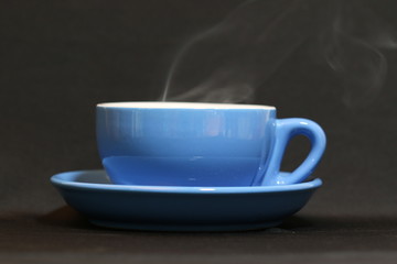 Steaming coffee cup on dark background