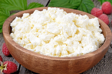 Fresh curd cheese in wooden bowl