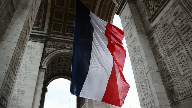 French Flag under Arch de Triumph during Victory Day celebration in Paris France