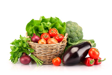 Full basket of ripe vegetables on white background