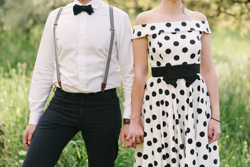 Vintage dressed couple in countryside holding hands