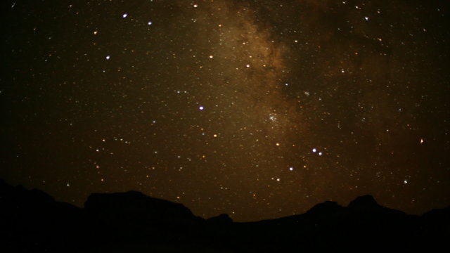 time lapse movie of a red rock region as the sun sets and stars appear