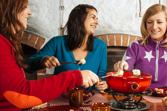 Three women having fondue dinner