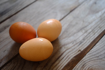 three fresh eggs on the wooden table