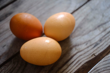 three fresh eggs on the wooden table