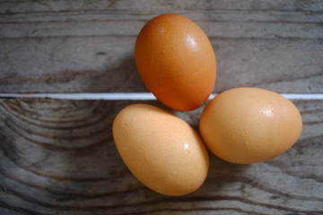 three fresh eggs on the wooden table