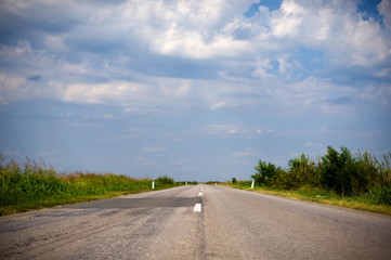 Country road with blue sky and clouds