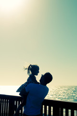 father and daughter walking on the beach