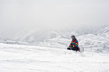 Snowboarder sit at top of mountain