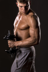 Fototapeta na wymiar muscular bodybuilder lifting weight with one arm