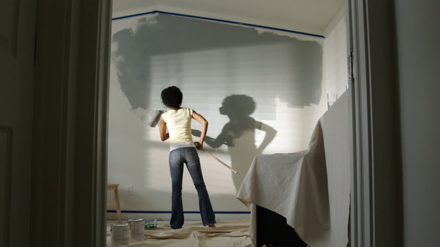 woman painting a bedroom