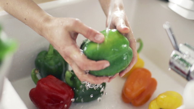 Woman washing pepper under tap water, slow motion 240fps
