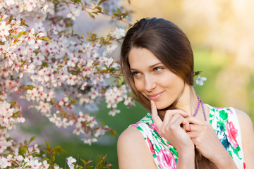 Beautiful  brunette woman in blooming orchard