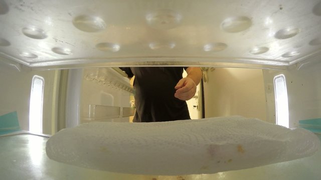 A man takes something from empty refrigerator MRL