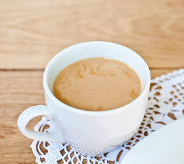 morning aromatic coffee with milk in white cup on a white napkin