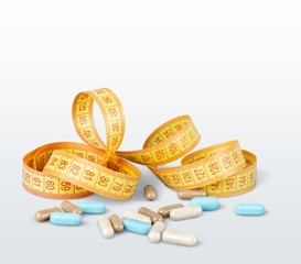 Supplement. Measuring tape and medicines on white background