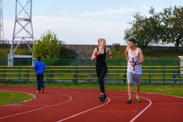 An attractive man and woman jogging on the track