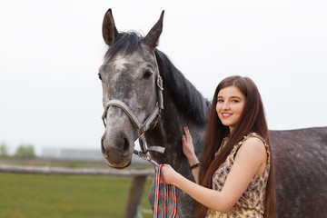 Obraz premium Young beautiful woman with a horse