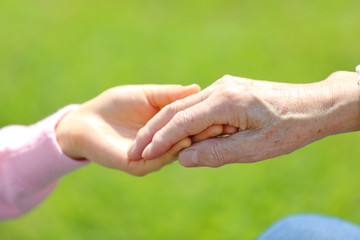 シニア男性の手を取る・新緑