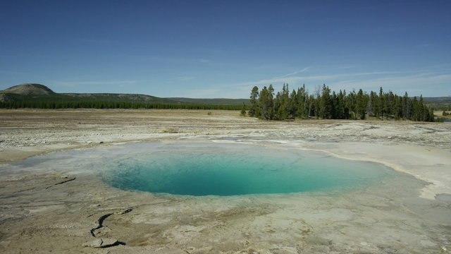 Wide panning shot of steam rising from opal pool / Yellowstone National Park, Wyoming, United States