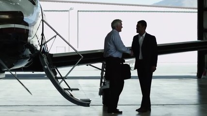 WS PAN MS Businessman disembarking private airplane and shaking hand with another businessman / Spanish Fork, Utah, USA - Powered by Adobe