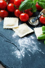 Uncooked ravioli with tomato and basil