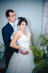 Charming bride with groom embraces and kisses on their wedding