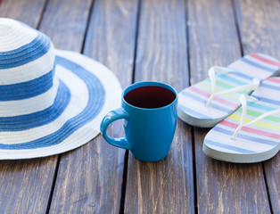 Cup of coffee and hat with flip flops