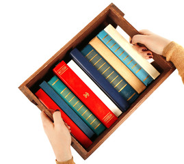 Books in wooden box in female hands isolated on white