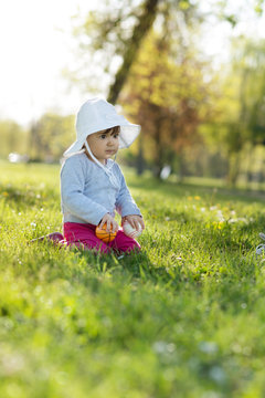 Cute little girl playing in the park on spring day